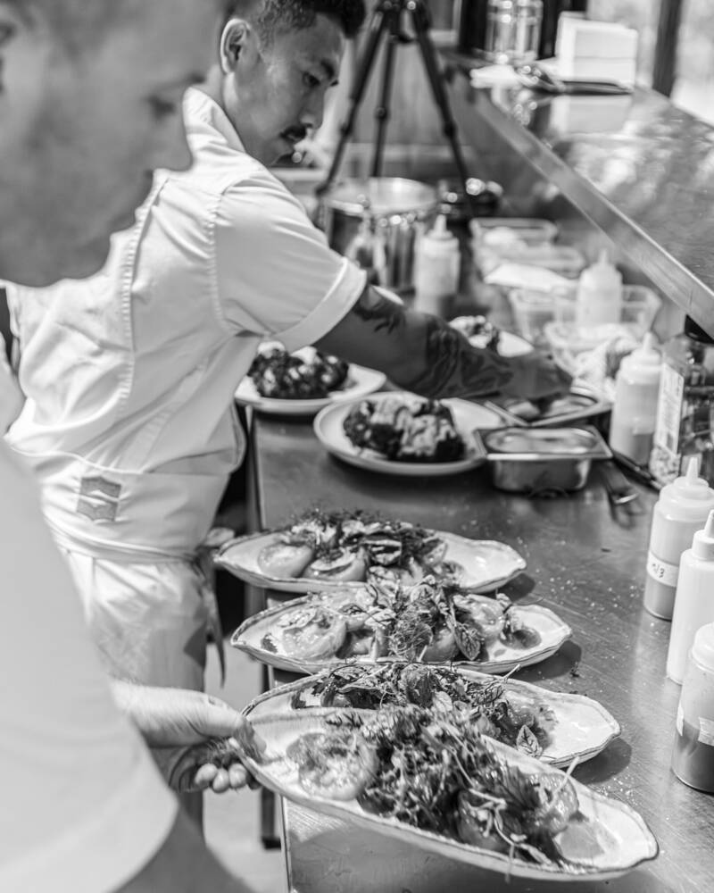 Plates of food being finished at the pass at Estancia Adina