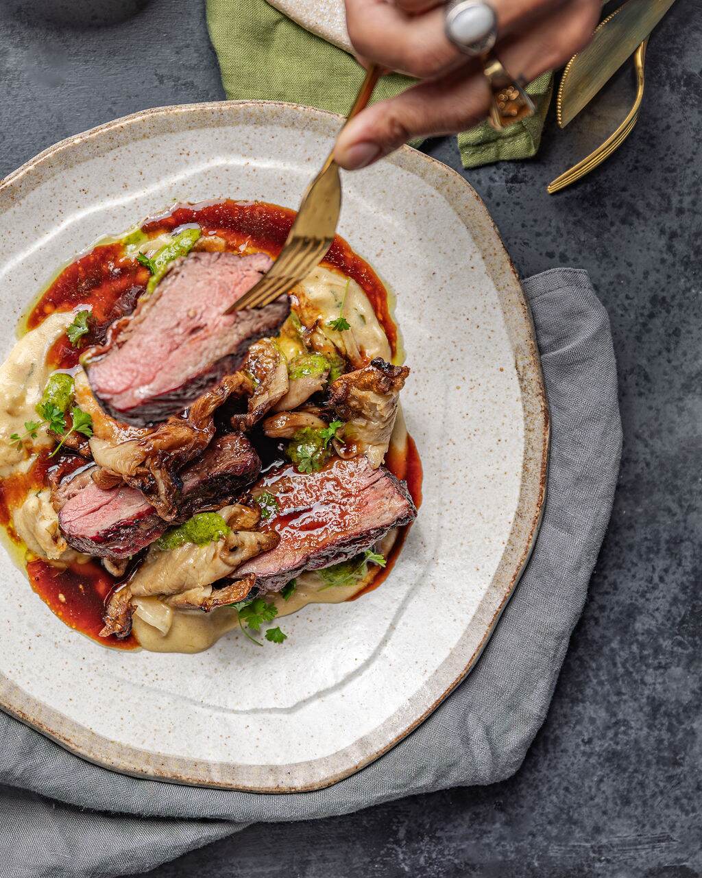 Chargrilled steak sliced over smoked mushroom pur&eacute;e and jus at Estancia Adina